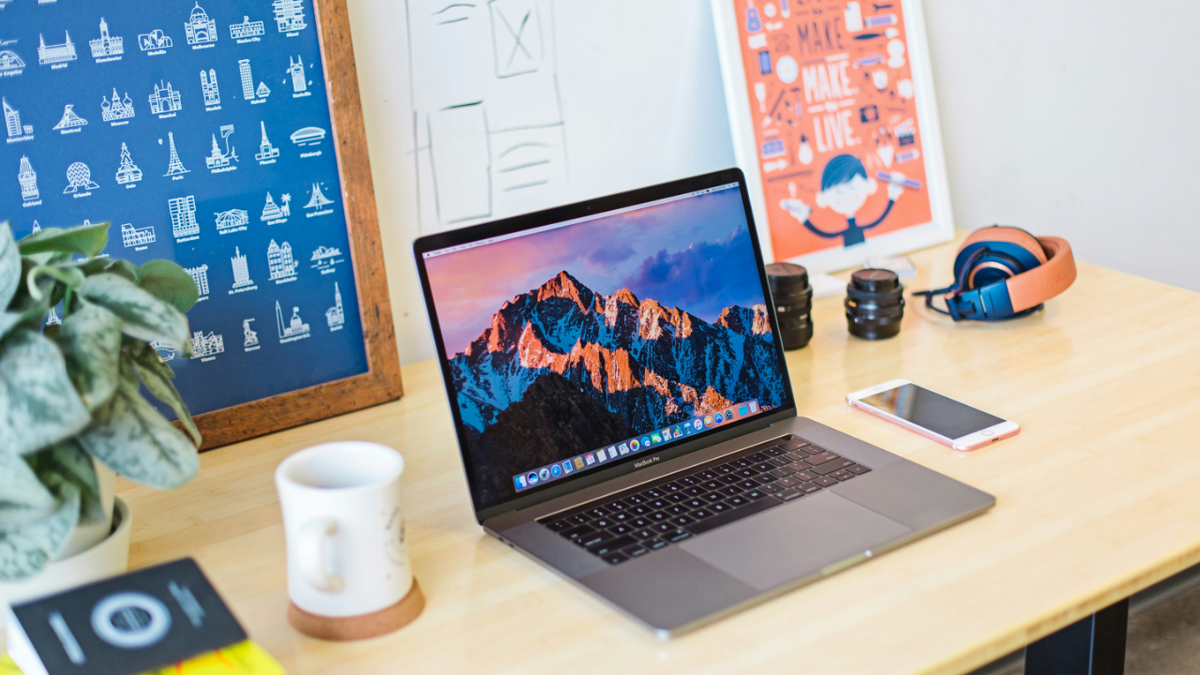 MacBook on a desk in a workspace setup for use as a monitor