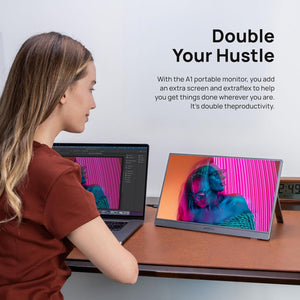 A woman using the ARZOPA A1 15.6 inch grey portable monitor as a dual screen setup with her laptop.