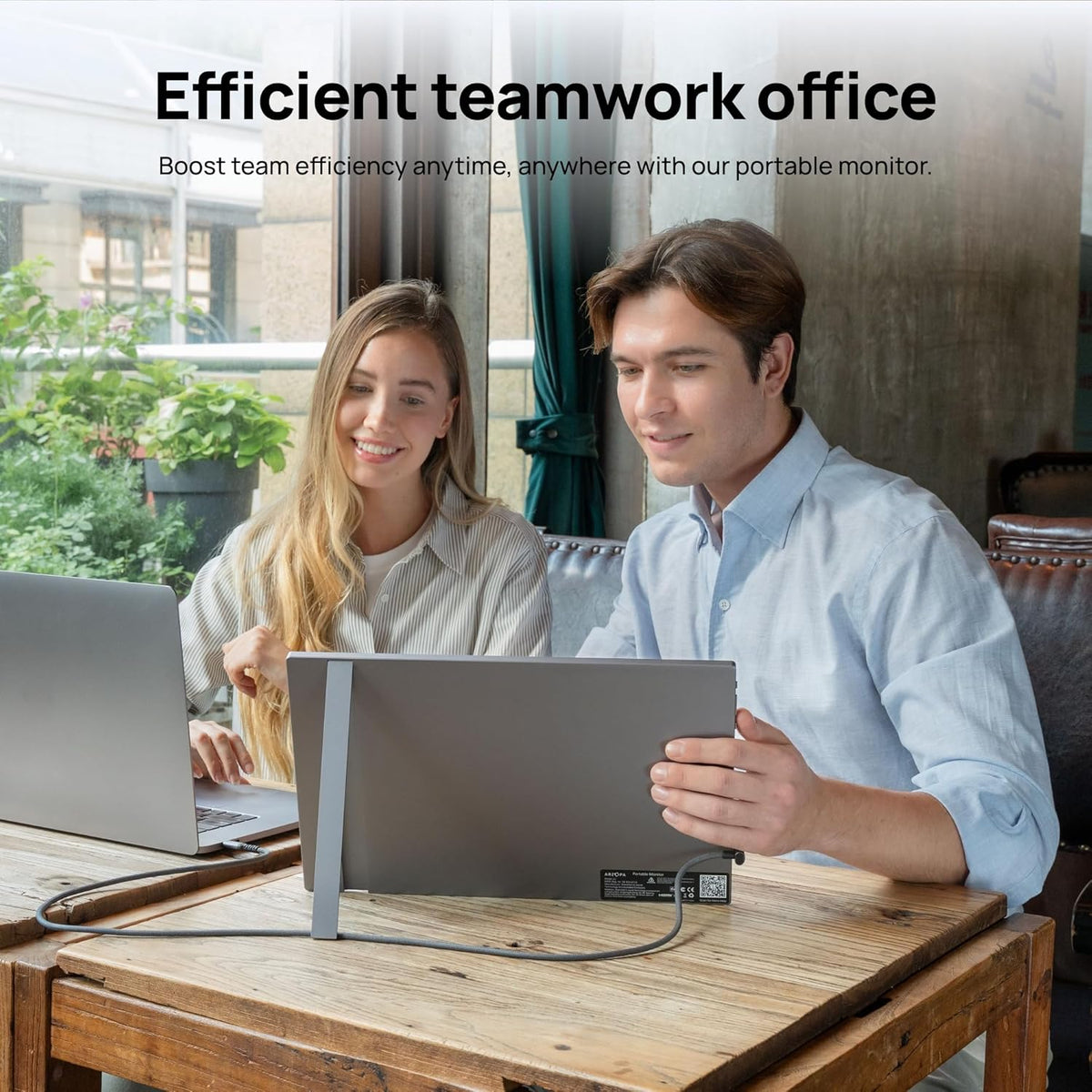 Two colleagues sharing work data using the ARZOPA A1 grey portable monitor for efficient teamwork in an office.