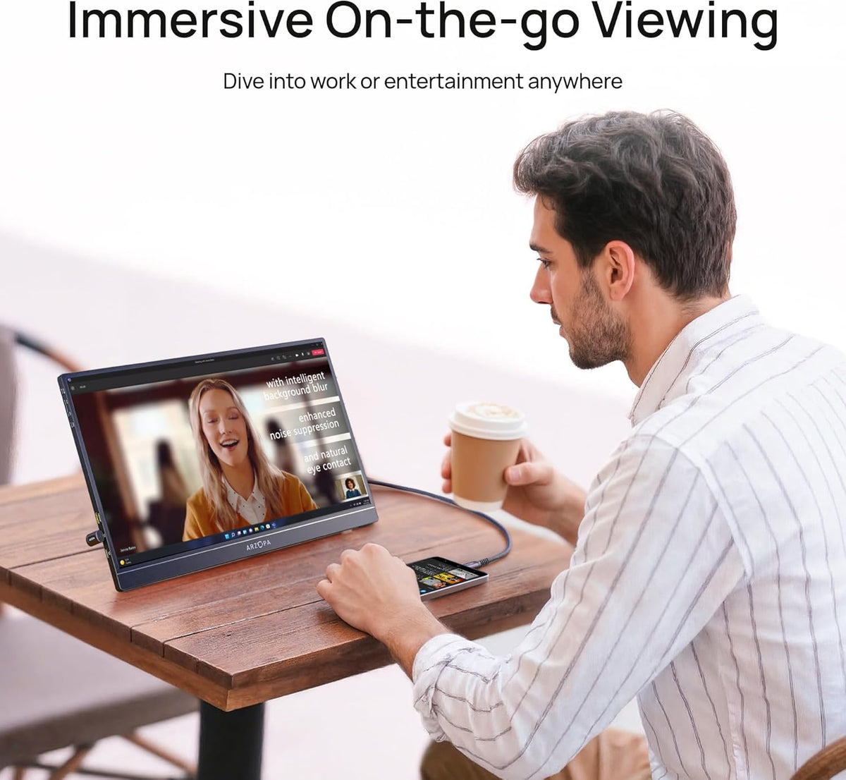 A man using the ARZOPA Z1C black portable monitor at a cafe table for video streaming and entertainment.
