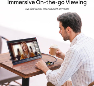 A man using the ARZOPA Z1C black portable monitor at a cafe table for video streaming and entertainment.